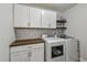 Well-organized laundry room featuring a washer, dryer, custom cabinets, and a stylish backsplash at 7546 Dunbridge Dr, Odessa, FL 33556