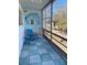 Screened balcony features a blue outdoor chair and painted wall art with scenic views and natural light at 8220 112Th St # 202, Seminole, FL 33772