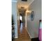 Hallway showcasing neutral wall colors and a wooden floor, leading to various rooms in the home at 8220 112Th St # 202, Seminole, FL 33772