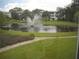 Scenic view of pond with fountain and residential buildings surrounded by lush greenery at 8220 112Th St # 202, Seminole, FL 33772