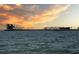 Distant pier view at sunset, with silhouetted structures along the horizon over the water at 100 4Th S Ave # 208, St Petersburg, FL 33701