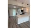 Modern kitchen with white cabinets, gray backsplash, stainless steel appliances and a view into the living space at 1000 49Th N St # 309, St Petersburg, FL 33710