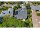 Aerial view of home showcasing solar panels on roof, screened porch, and mature landscaping at 1006 Osprey Ct, Tarpon Springs, FL 34689