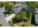 Aerial view of a well-maintained home with a long driveway, a two-car garage, and lush tropical landscaping at 1006 Osprey Ct, Tarpon Springs, FL 34689