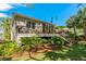 Backyard view features a deck with outdoor seating, lush landscaping, and stairs to the ground level at 1006 Osprey Ct, Tarpon Springs, FL 34689