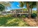 Backyard with deck, stairs, and lush tropical landscaping with lots of shade at 1006 Osprey Ct, Tarpon Springs, FL 34689