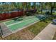 Outdoor shuffleboard courts on a concrete surface with lush green landscape, benches and a fence in the background at 1006 Osprey Ct, Tarpon Springs, FL 34689