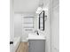 Clean bathroom with sleek black fixtures, a gray vanity, a modern mirror, and tile accents at 1008 E Norfolk St, Tampa, FL 33604