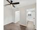 Bedroom with ceiling fan showing a hallway closet and ensuite bathroom with a tiled shower at 1008 E Norfolk St, Tampa, FL 33604