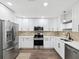 Modern kitchen featuring stainless steel appliances, white cabinetry, and a stylish backsplash at 1008 E Norfolk St, Tampa, FL 33604
