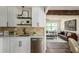 Open kitchen with stainless steel dishwasher, white cabinets, and access to the living room at 1008 E Norfolk St, Tampa, FL 33604