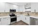 Bright kitchen featuring white cabinets, stainless steel appliances, and stone backsplash at 1008 E Norfolk St, Tampa, FL 33604
