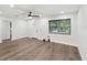 Bright living room with modern ceiling fan, wood-look floors, and natural light from a window at 1008 E Norfolk St, Tampa, FL 33604