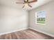 Bright bedroom with wood-look floors, ceiling fan, and window with natural light at 11050 Auburndale St, Spring Hill, FL 34609