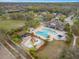 Aerial view of a community pool, splash pad, and clubhouse with lush landscaping at 11218 Coventry Grove Cir, Lithia, FL 33547