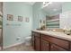 Bright bathroom with a single sink vanity, framed art, and a shower-tub combo at 11218 Coventry Grove Cir, Lithia, FL 33547