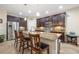 Kitchen featuring stainless steel refrigerator, dark cabinetry, tile floors, and a granite topped island at 11218 Coventry Grove Cir, Lithia, FL 33547