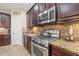 Close up of kitchen with stainless steel oven, granite countertop, tiled backsplash and dark cabinets at 11218 Coventry Grove Cir, Lithia, FL 33547