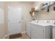 A functional laundry room with a washer, dryer, shelving, and access to the house at 11218 Coventry Grove Cir, Lithia, FL 33547