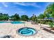 Community pool area featuring a hot tub, lounge chairs, and lush tropical landscaping at 11218 Coventry Grove Cir, Lithia, FL 33547