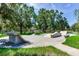 Outdoor skate park featuring concrete ramps, rails, and benches surrounded by mature trees at 11218 Coventry Grove Cir, Lithia, FL 33547
