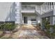 Charming condo exterior with gray siding, stone walkway, and well-maintained landscaping at 12041 Hoosier Ct # 104, Hudson, FL 34667