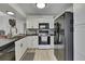 Bright kitchen featuring white cabinets, black appliances, and a cozy, modern design at 12041 Hoosier Ct # 104, Hudson, FL 34667