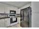 Well-lit kitchen featuring white cabinets, black appliances, and a stylish subway tile backsplash at 12041 Hoosier Ct # 104, Hudson, FL 34667