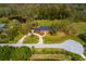 Aerial view of an estate featuring manicured lawns, mature trees, a private pond, and circular driveway at 12603 Corral Rd, Tampa, FL 33626