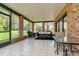 Enclosed patio with brick accents, comfortable seating, and tile flooring, perfect for relaxing and entertaining at 12603 Corral Rd, Tampa, FL 33626