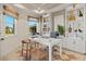 Bright home office featuring built-in shelving, natural light, and a modern white desk with stylish decor at 12785 Jade Empress Loop # 102, Venice, FL 34293