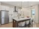 A modern kitchen boasts white cabinets, stainless steel appliances, and a center island with seating at 12785 Jade Empress Loop # 102, Venice, FL 34293