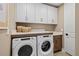 Bright laundry room featuring a Whirlpool washer and dryer with white cabinets and a countertop at 12785 Jade Empress Loop # 102, Venice, FL 34293