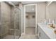 Main bathroom featuring a glass-enclosed shower, vanity with countertop, and a walk-in closet at 12785 Jade Empress Loop # 102, Venice, FL 34293