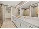 Elegant main bathroom featuring dual vanities, modern fixtures, and access to a walk-in closet at 12785 Jade Empress Loop # 102, Venice, FL 34293