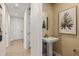 Stylish powder room featuring a pedestal sink, textured wallpaper, and modern decor at 12785 Jade Empress Loop # 102, Venice, FL 34293