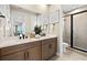 Bathroom featuring a dual sink vanity, a shower, and framed artwork at 12785 Jade Empress Loop # 201, Venice, FL 34293