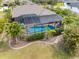 An aerial view of a home with a screened-in pool, surrounded by lush landscaping at 135 Cabana Way, Rotonda West, FL 33947