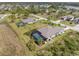 An aerial view of homes with screened-in pools and lush landscaping in a suburban neighborhood at 135 Cabana Way, Rotonda West, FL 33947
