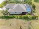 Aerial view showcasing the back of the home, landscaping and an inviting, screened-in pool at 135 Cabana Way, Rotonda West, FL 33947