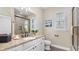 Bathroom with granite countertops, modern fixtures, shower with glass door, and plantation shutters at 135 Cabana Way, Rotonda West, FL 33947