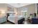 Cozy bedroom featuring a blue bed frame, wood-look flooring, and a window with plantation shutters at 135 Cabana Way, Rotonda West, FL 33947
