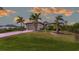 Exterior shot of a home with a well manicured lawn and landscaping with palm trees at 135 Cabana Way, Rotonda West, FL 33947