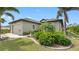 Charming home featuring a two-car garage, lush landscaping, and a well-manicured lawn at 135 Cabana Way, Rotonda West, FL 33947