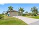 Inviting home showcasing a concrete driveway, mature landscaping, and a two-car garage at 135 Cabana Way, Rotonda West, FL 33947