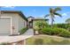 Attractive single-story home with a landscaped yard, mature trees, and inviting entryway at 135 Cabana Way, Rotonda West, FL 33947