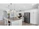 Modern kitchen with stainless appliances, white cabinets, breakfast bar, and pendant lighting at 135 Cabana Way, Rotonda West, FL 33947