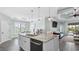 Bright, modern kitchen with a large island, stainless steel appliances, and pendant lighting at 135 Cabana Way, Rotonda West, FL 33947