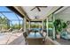 Spacious lanai offering dining and seating areas with views of the pool and verdant landscaping at 135 Cabana Way, Rotonda West, FL 33947
