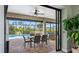 A covered outdoor lanai with dining area, sliding glass doors, and views of the pool at 135 Cabana Way, Rotonda West, FL 33947